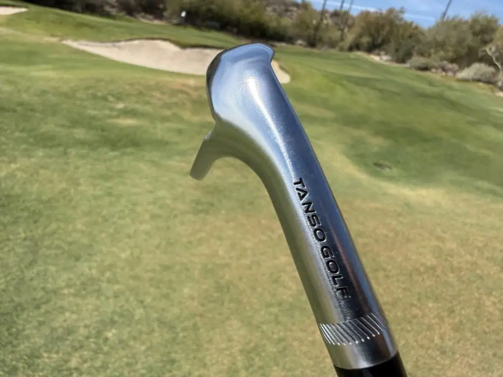 Hosel and shaft of an M-grind Tour-W wedge near a bunker